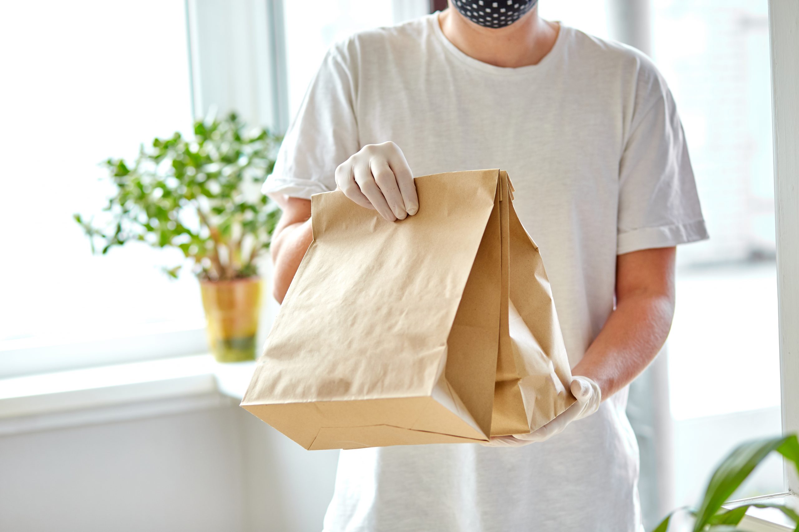 Courierin white hold go box food, delivery service, Takeaway restaurants food delivery to home door. Stay at home safe lives from coronavirus COVID-19 outbreak. Contactless delivery service under quarantine.